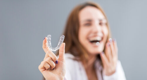 Women Smiling Holding Invisalign
