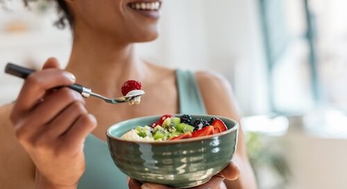 Woman Eating Bowl of Fruit