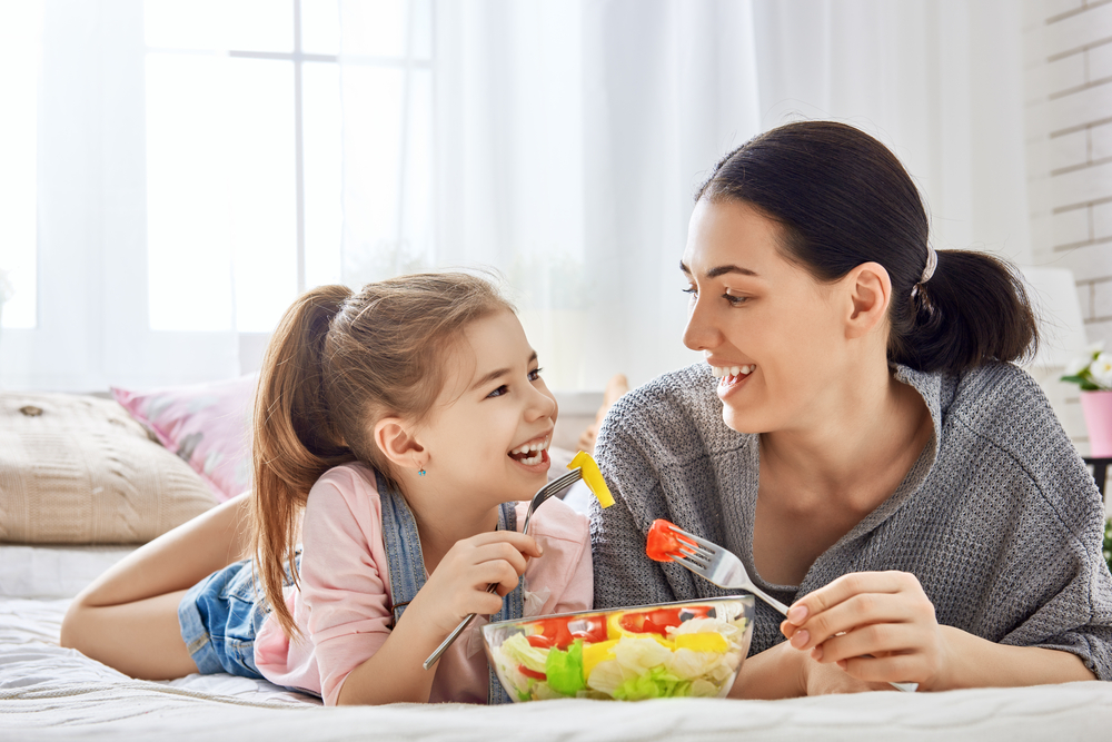 mother and daughter eating salad together