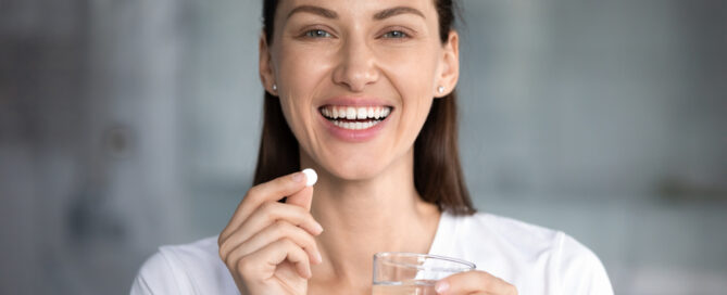 woman taking an oral probiotic