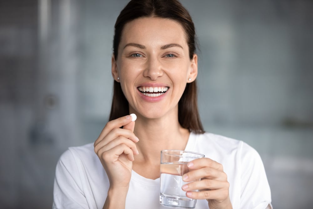 woman taking an oral probiotic