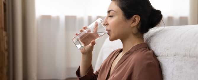 woman drinking water for dry mouth prevention