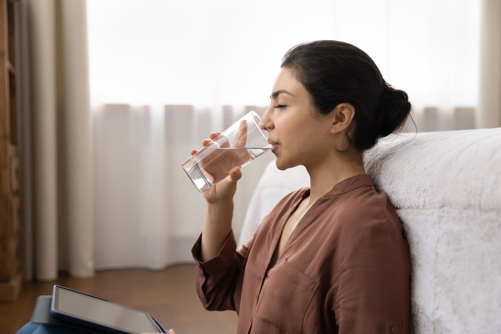 woman drinking water for dry mouth prevention