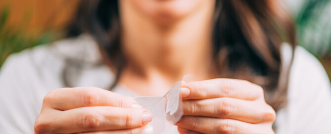 woman with a teeth whitening strip