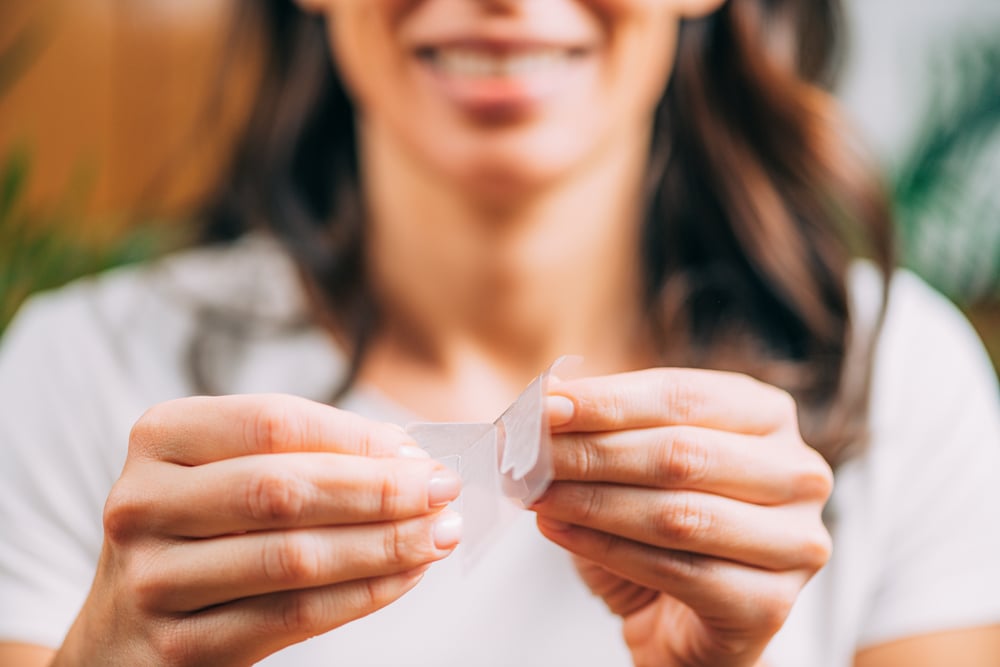 woman with a teeth whitening strip