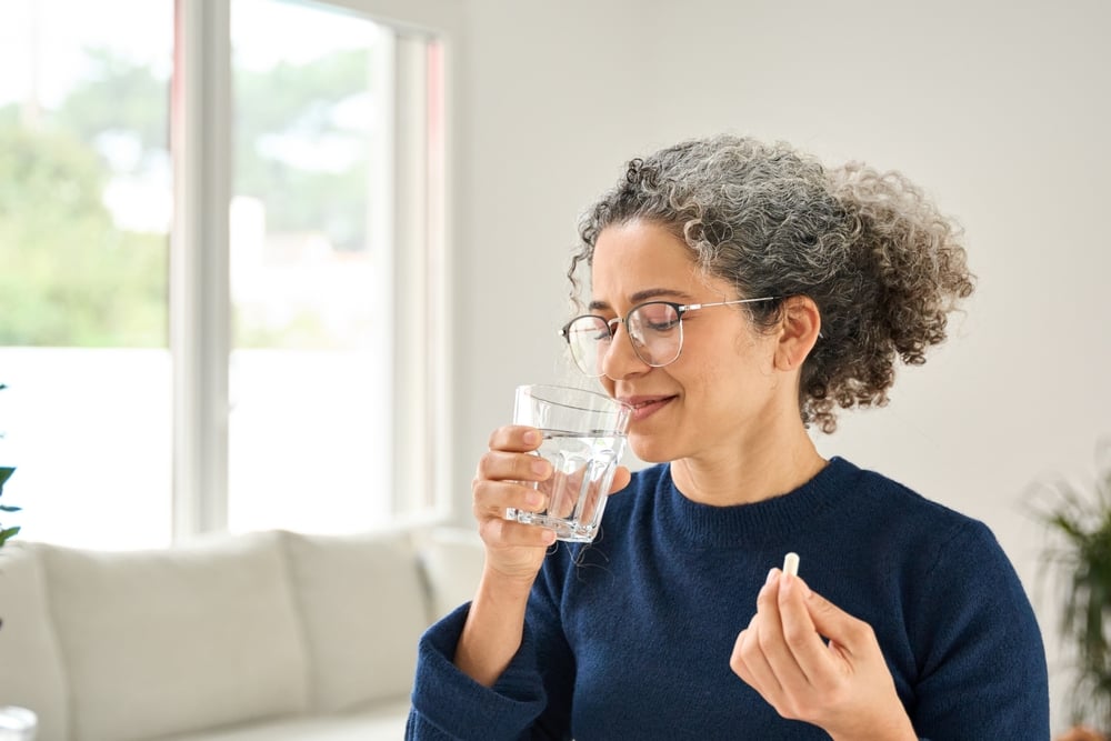woman taking vitamins for gun health