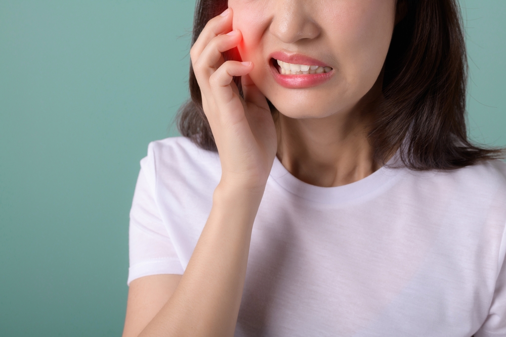 Woman with a toothache holding cheek