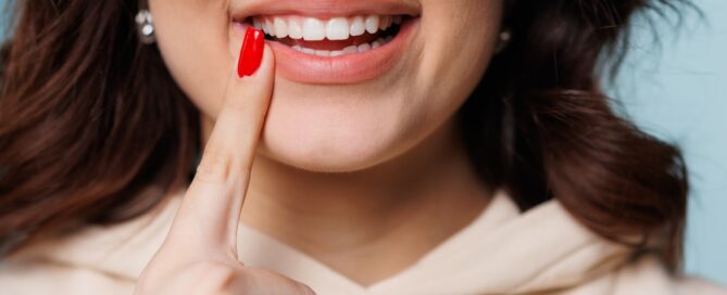 how to strengthen tooth enamel - image of a woman pointing to her teeth