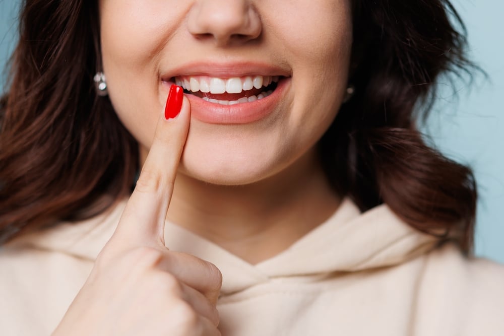 how to strengthen tooth enamel - image of a woman pointing to her teeth
