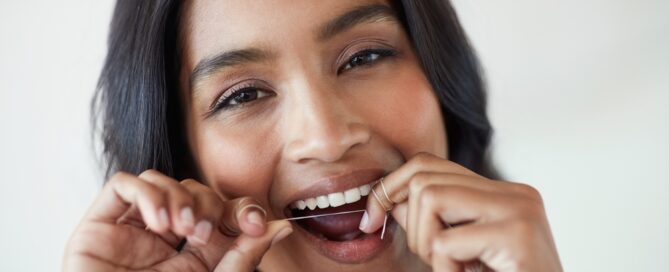 image of a woman showing how to floss properly